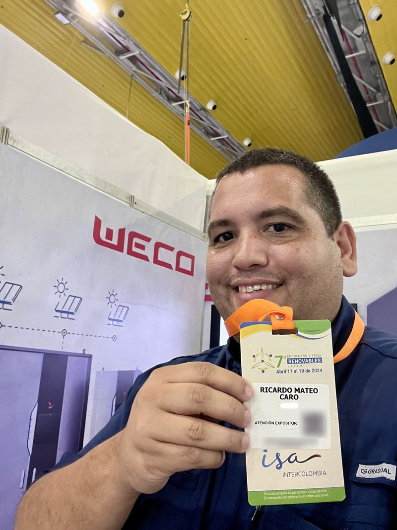 Ricardo Caro Mateo con il suo badge da espositore del 7° Incontro e Fiera Renovables LATAM, davanti allo stand di WeCo, a Barranquilla