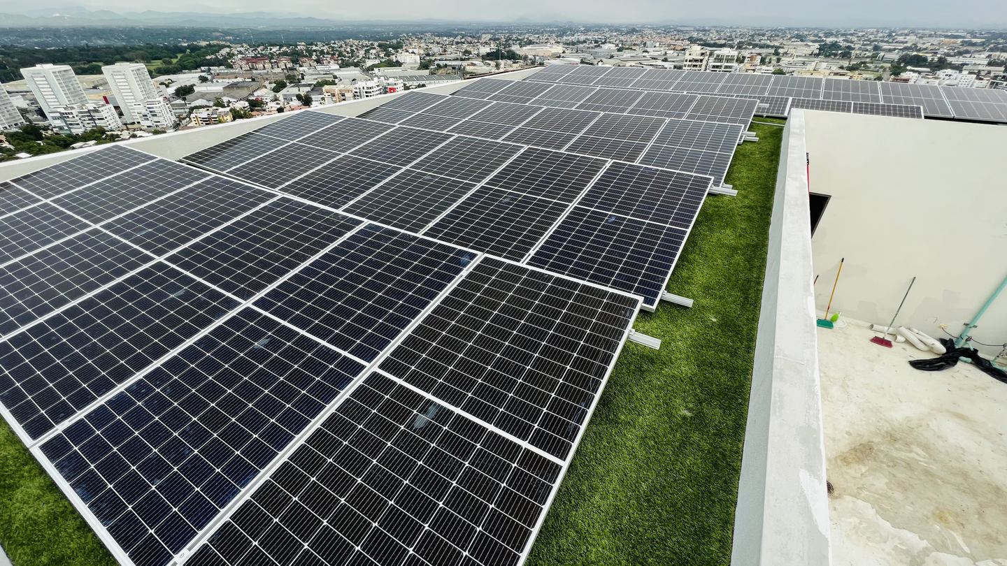 Planta solar sobre la azotea de un edificio comercial con la ciudad al fondo