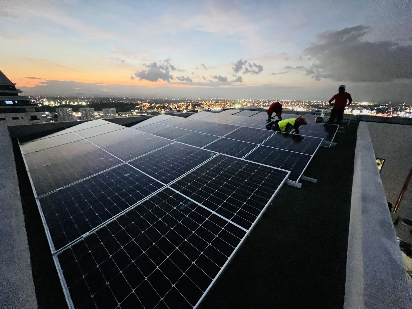 Instaladores terminando una planta solar en azotea al atardecer