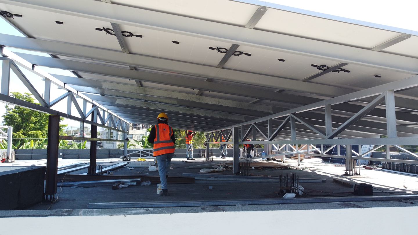 Montaje de la estructura metálica que soporta los paneles solares en una sucursal de Banreservas