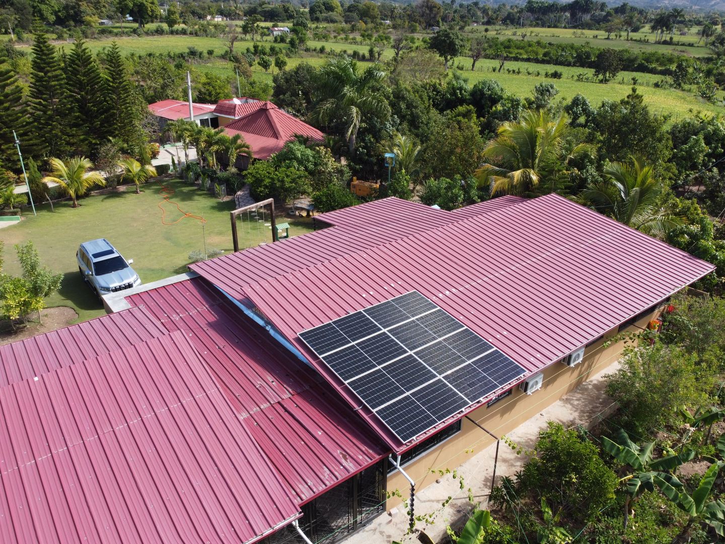 Residencia en entorno rural con paneles solares sobre el techo metálico