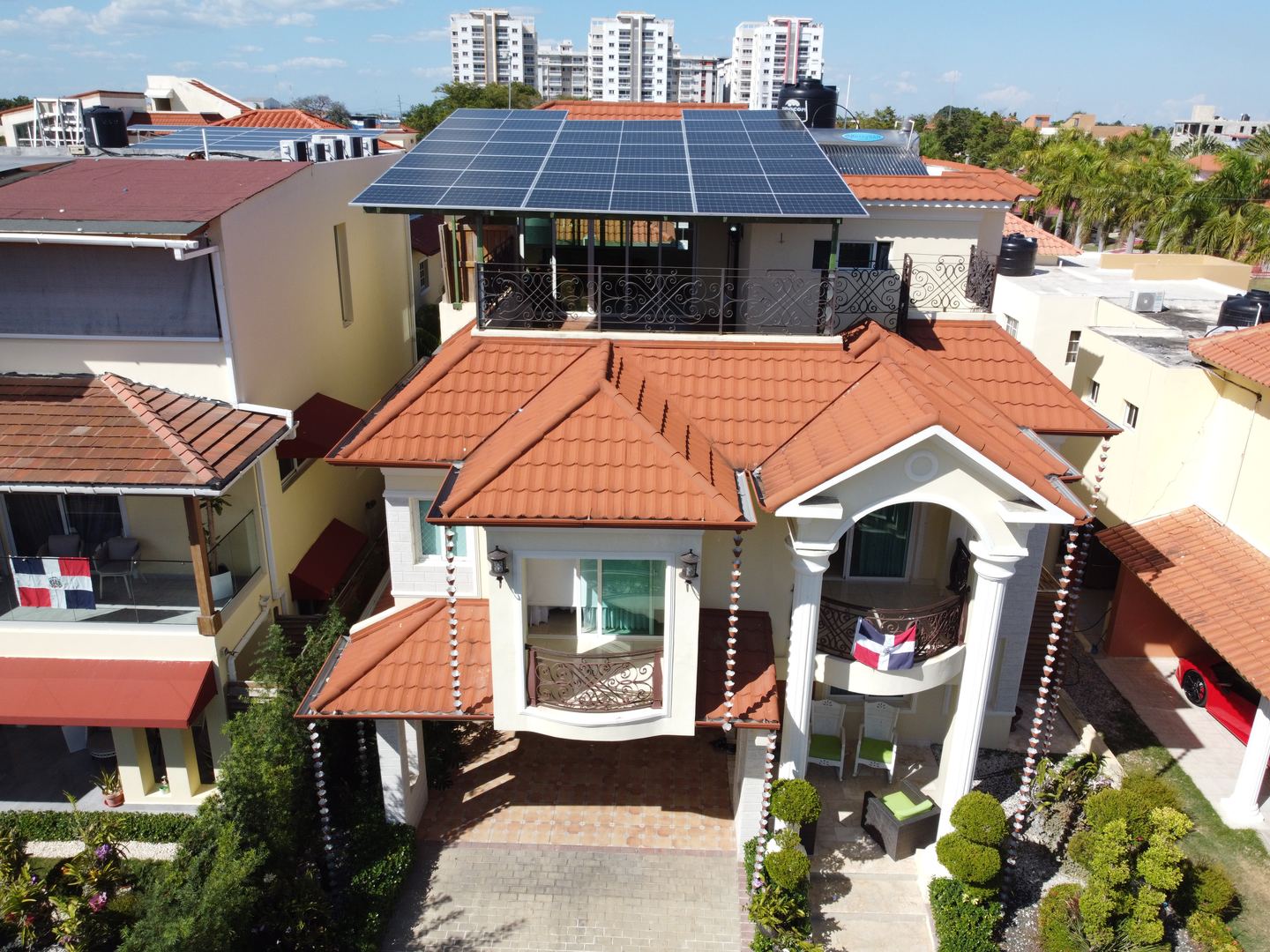 Fachada de una residencia con paneles solares sobre la pérgola de la terraza