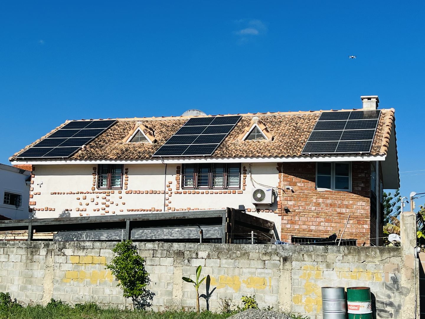 Fachada de una residencia con paneles solares integrados en el techo de teja