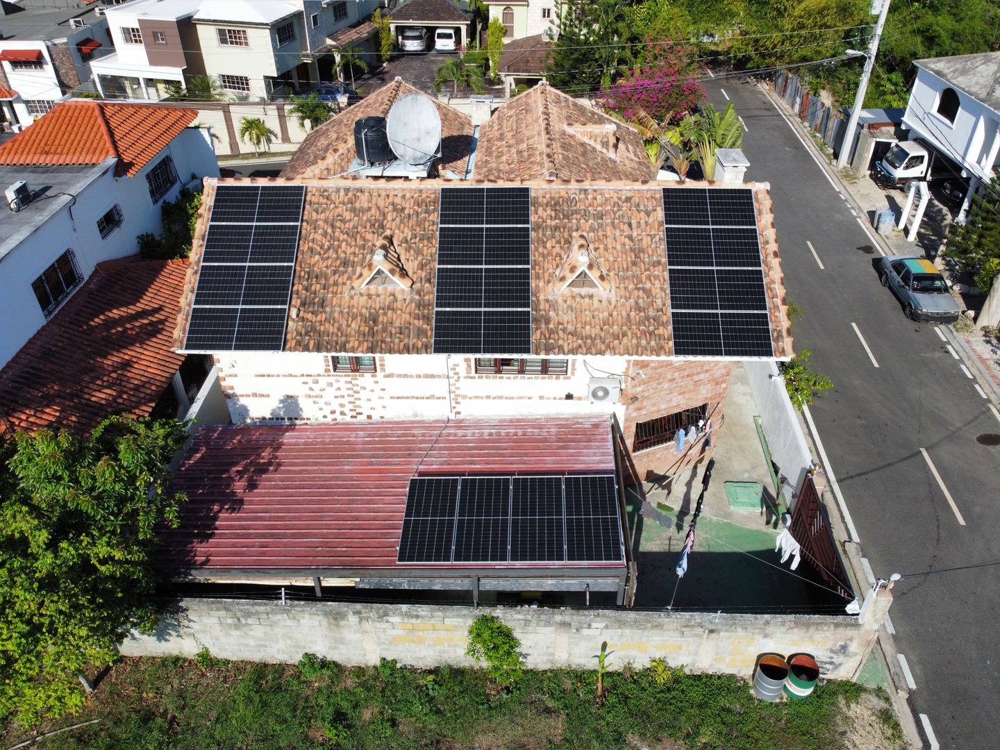 Vista aérea de una residencia de techo de teja con varios grupos de paneles solares