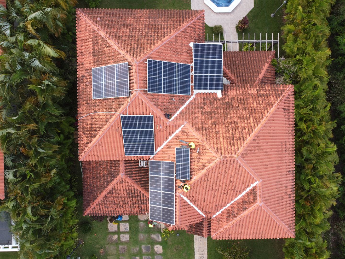 Vista cenital de una residencia de techo de teja con paneles solares