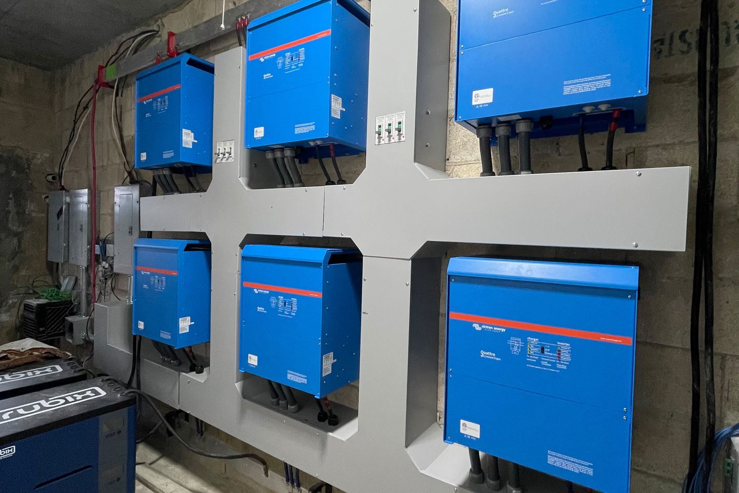 Inversores-cargadores Victron Energy montados en la pared de una sala técnica