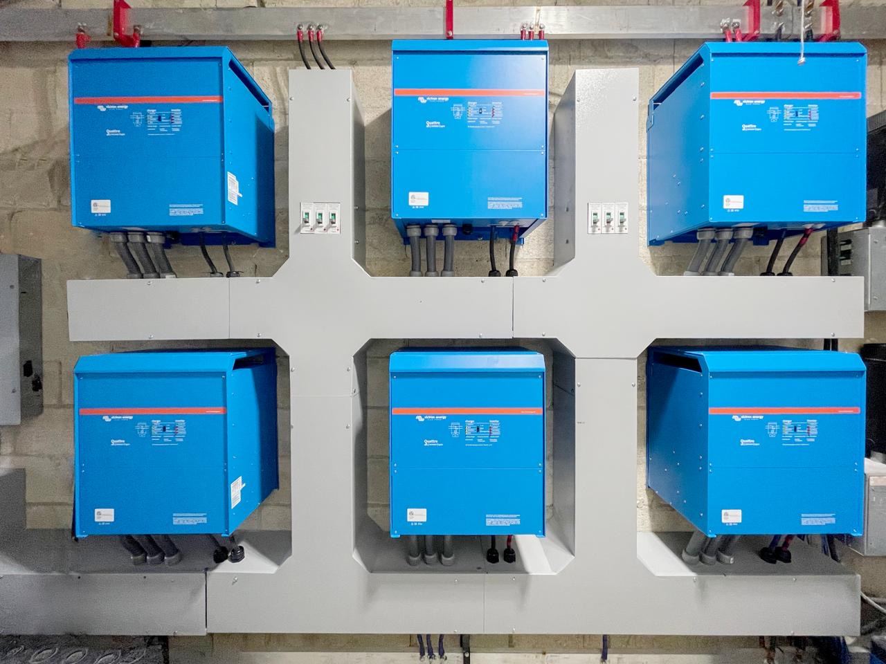 Seis inversores-cargadores Victron Energy instalados en pared con su canalización eléctrica