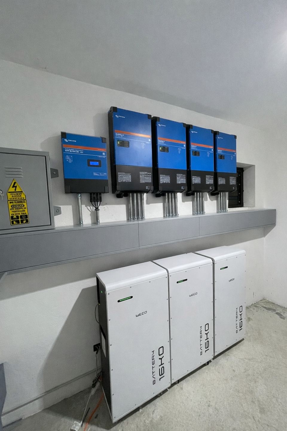Inversores-cargadores Victron Energy con tres baterías WECO 16K0 en una sala técnica